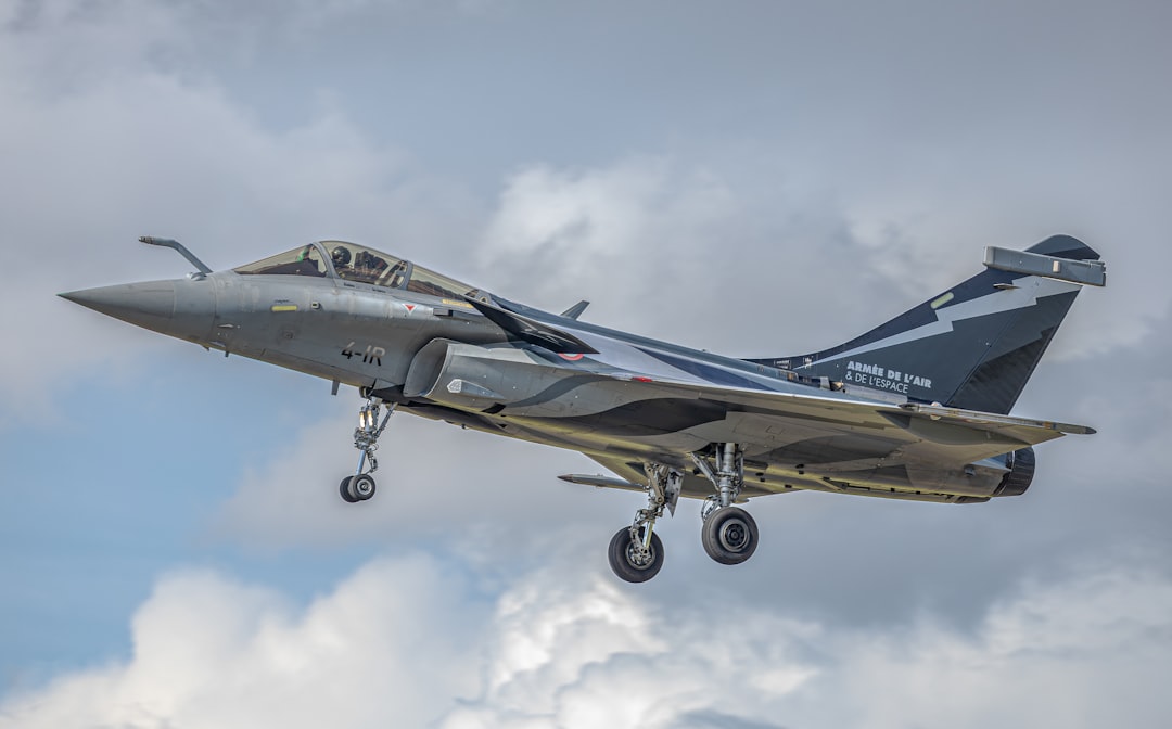 Photo by david hili a fighter jet flying through a cloudy sky